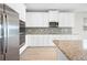 Bright kitchen features white cabinets, granite countertops, stainless steel appliances and mosaic backsplash at 17618 Cortes Creek Blvd, Spring Hill, FL 34610