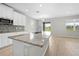 Open kitchen with island, granite countertops, stainless steel sink and appliances and slider to the patio at 17618 Cortes Creek Blvd, Spring Hill, FL 34610