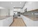 Kitchen featuring stainless steel appliances, granite counters, white cabinets and backsplash at 17618 Cortes Creek Blvd, Spring Hill, FL 34610