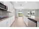 Gourmet kitchen with white cabinets, granite counters, stainless appliances and tile backsplash and tile floors at 17618 Cortes Creek Blvd, Spring Hill, FL 34610