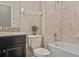 Elegant bathroom features a granite countertop, black vanity, and tiled shower/tub combination at 18428 Malinche Loop, Spring Hill, FL 34610