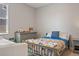 Cozy bedroom boasts colorful bedding, grey dresser, and a window that allows natural light in at 18428 Malinche Loop, Spring Hill, FL 34610