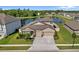 Beautiful home featuring a manicured lawn, stone accents, a three-car garage and a picturesque lake view at 18428 Malinche Loop, Spring Hill, FL 34610