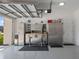 Organized garage equipped with storage cabinets, work bench, stools, and epoxy flooring at 18428 Malinche Loop, Spring Hill, FL 34610