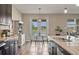 Kitchen view with stainless steel appliances, granite counters, and breakfast table with scenic views at 18428 Malinche Loop, Spring Hill, FL 34610