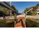 Waterfront view from a private dock with boat lift, surrounded by lush greenery and a glimpse of the home at 1857 Bayou Grande Ne Blvd, St Petersburg, FL 33703