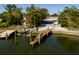 Aerial view of a waterfront property with a pool, boat dock, lift, and lush tropical landscaping at 1857 Bayou Grande Ne Blvd, St Petersburg, FL 33703