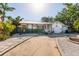 Charming single-story home featuring a metal roof, white exterior with decorative accents, and a well-manicured front yard at 1857 Bayou Grande Ne Blvd, St Petersburg, FL 33703
