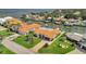 Aerial view of waterfront property with lush landscaping, terracotta roof, and convenient boat access to open water at 1901 Kansas Ne Ave, St Petersburg, FL 33703