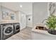 Modern laundry room with marble counters, sink, and gray wood-look flooring at 1901 Kansas Ne Ave, St Petersburg, FL 33703