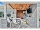Outdoor kitchen area with stone counter seating, wood ceiling, and stainless steel appliances for entertaining at 1901 Kansas Ne Ave, St Petersburg, FL 33703