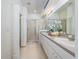 Bright bathroom featuring double sinks, white cabinets, and a glass-enclosed shower at 19137 Lake Audubon Dr, Tampa, FL 33647