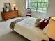 Cozy bedroom featuring a dresser, a chair, and a large window with views of the outdoors at 19137 Lake Audubon Dr, Tampa, FL 33647