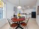Breakfast nook featuring wood table and iron chairs leading to a bright kitchen with white cabinets at 19137 Lake Audubon Dr, Tampa, FL 33647