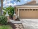 Garage of a home featuring neutral siding, a manicured lawn and attractive landscaping at 19137 Lake Audubon Dr, Tampa, FL 33647