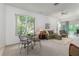 Cozy living room with large window, comfortable seating, and sliding glass doors to screened lanai at 19137 Lake Audubon Dr, Tampa, FL 33647