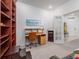 Well lit office with hardwood desk, shelves, and view to hallway at 19137 Lake Audubon Dr, Tampa, FL 33647