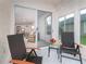 Cozy screened patio with chairs, table, and view to living room at 19137 Lake Audubon Dr, Tampa, FL 33647