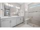 Well-lit bathroom with double sinks and a glass enclosed shower with a bench at 1978 Pepper Grass Dr, North Port, FL 34289