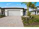 Charming single-story home featuring a paver driveway, two-car garage, and professionally landscaped yard at 1978 Pepper Grass Dr, North Port, FL 34289