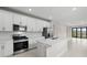 Stylish kitchen featuring stainless steel appliances, a kitchen island, and neutral countertops at 1978 Pepper Grass Dr, North Port, FL 34289