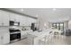 Bright kitchen with white cabinets, stainless steel appliances, and a large island at 1978 Pepper Grass Dr, North Port, FL 34289