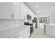 Modern kitchen featuring white cabinets, stainless steel appliances, and a quartz countertop at 1978 Pepper Grass Dr, North Port, FL 34289