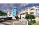Exterior view of townhouses with colorful exteriors, balconies, and lush landscaping at 20 Outlook Way # 10, Dunedin, FL 34698