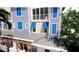 Multi-story townhouse with blue shutters and a balcony, plus a pergola and partial view of the roof at 20 Outlook Way # 10, Dunedin, FL 34698