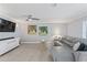 Well-lit living room with a sectional sofa, modern ceiling fan, and wall art at 2132 Academy Dr, Clearwater, FL 33764