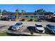 Two-story condo complex featuring a mix of car parking and tropical palm trees against a blue sky backdrop at 2353 Shelley St # 6, Clearwater, FL 33765