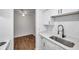 Modern kitchen featuring white cabinetry, stainless sink, and updated fixtures, adjacent to living space at 2353 Shelley St # 6, Clearwater, FL 33765