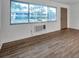 Bright living room featuring wood-look tile flooring, large window, and a front door at 2353 Shelley St # 6, Clearwater, FL 33765