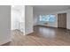 Bright open-concept living area with wood-look tile floors, large window, and a view into the kitchen at 2353 Shelley St # 6, Clearwater, FL 33765