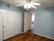 Bedroom featuring wood floors, light blue walls, and a ceiling fan at 2447 Ecuadorian Way # 11, Clearwater, FL 33763