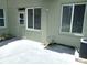 Rear exterior featuring an entrance door, windows with blinds, a patio area, and an air conditioning unit at 2447 Ecuadorian Way # 11, Clearwater, FL 33763
