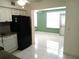 Bright kitchen featuring white cabinets, tile flooring, and a black refrigerator at 2447 Ecuadorian Way # 11, Clearwater, FL 33763