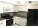 Updated kitchen with stainless steel appliances, granite countertops, and white cabinetry at 2447 Ecuadorian Way # 11, Clearwater, FL 33763