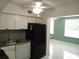 Kitchen including white cabinets, black appliances, and tile backsplash at 2447 Ecuadorian Way # 11, Clearwater, FL 33763