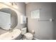 Neutral bathroom features a round mirror, pedestal sink, and toilet at 2542 Glenrise Pl, Wesley Chapel, FL 33544