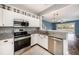 Kitchen featuring stainless steel appliances, granite countertops and an opening to the living room at 2542 Glenrise Pl, Wesley Chapel, FL 33544