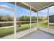 Enclosed lanai offering serene views of the pond and lush greenery at 2542 Glenrise Pl, Wesley Chapel, FL 33544