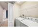 Bright laundry room featuring a modern washer and dryer, and a wire shelf for storage at 2542 Glenrise Pl, Wesley Chapel, FL 33544
