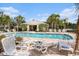 Community pool area with comfortable lounge chairs, set amidst tropical palm trees at 2542 Glenrise Pl, Wesley Chapel, FL 33544