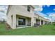 Townhome exterior features a covered patio, green grass, and lush landscaping at 255 Royal Spoonbill Dr, Ruskin, FL 33570