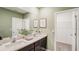 Well lit bathroom features a double vanity and view to walk-in closet at 255 Royal Spoonbill Dr, Ruskin, FL 33570