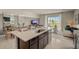 Modern kitchen features an island with sink and seating, stainless appliances, and an open layout to the living area at 255 Royal Spoonbill Dr, Ruskin, FL 33570