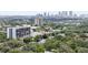 Aerial view showcasing the building's location amongst lush greenery with the city skyline in the distance at 3211 W Swann Ave # 605, Tampa, FL 33609