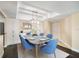 Formal dining area featuring a marble-top table with six blue chairs and stylish light fixture at 3211 W Swann Ave # 605, Tampa, FL 33609