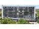 Full exterior shot of a modern condo building with multiple balconies and lush surrounding trees at 3211 W Swann Ave # 605, Tampa, FL 33609